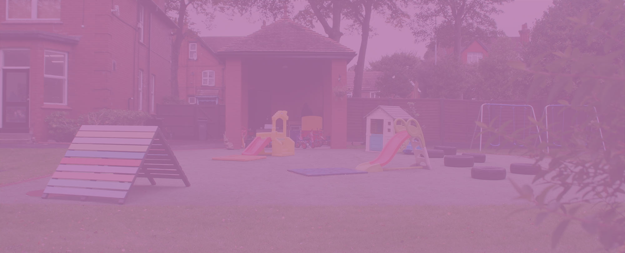 The outdoor play area, with slides, a playhouse, swings and a climbing frame